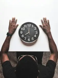 A man waiting next to a clock