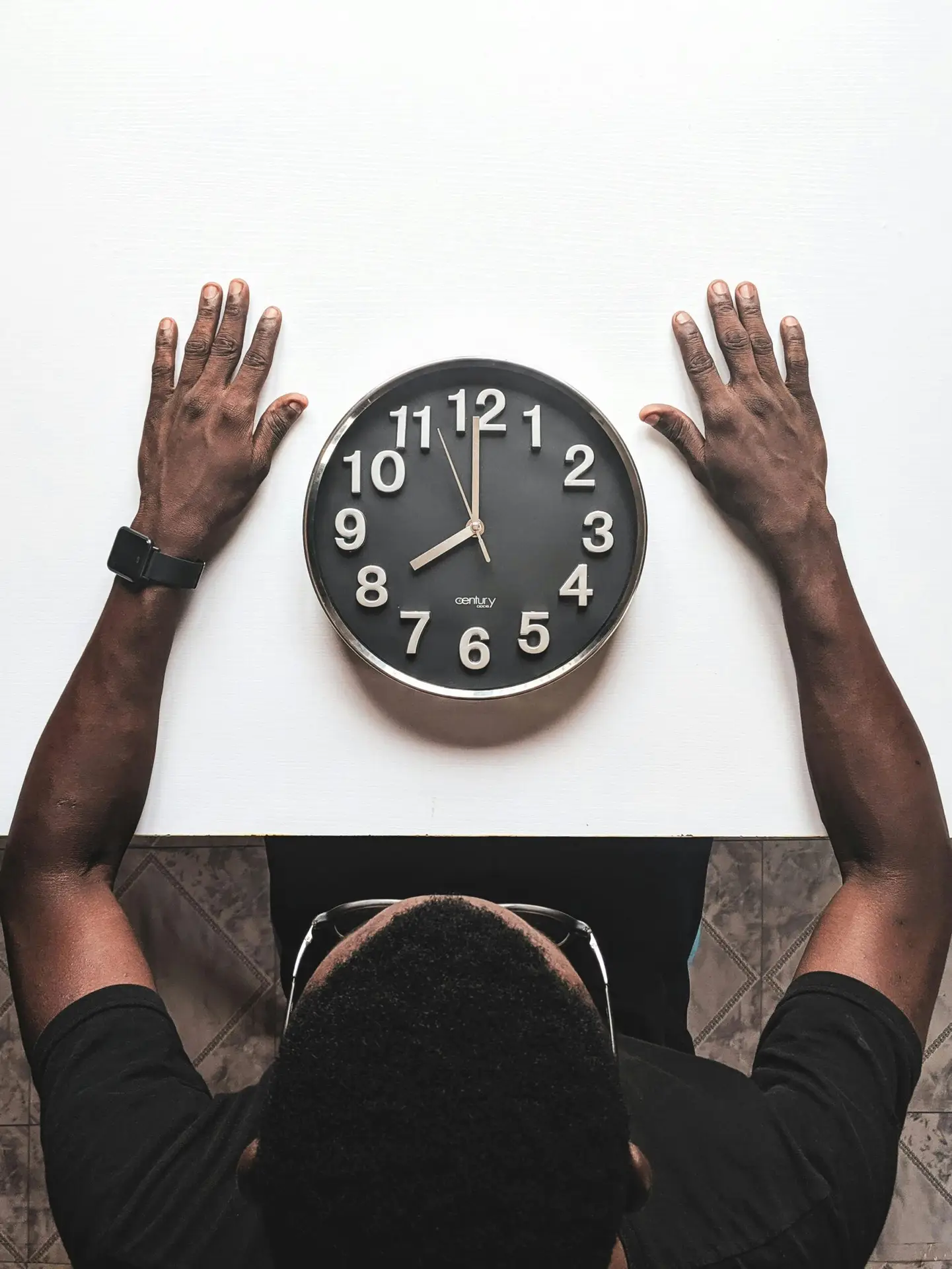 A man waiting next to a clock